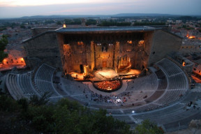 Vue éclairée à la nuit tombante du théâtre des Chorégies d'Orange