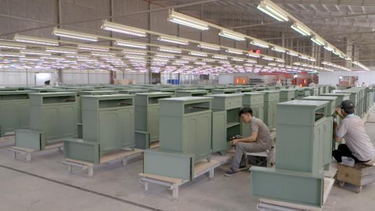 Une usine vietnamienne où des ouvriers finissent d'assembler des meubles