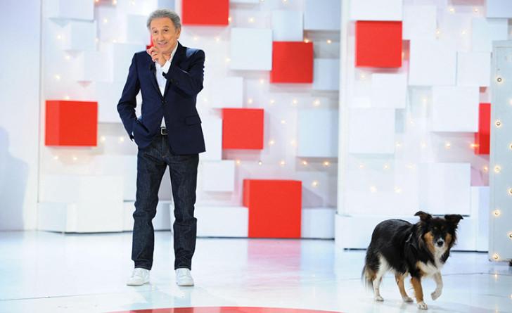 Photo de Michel Drucker sur le plateau de l'émission, en compagnie de sa chienne