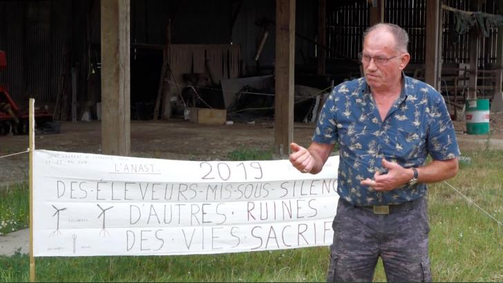 Un agriculteur devant une banderole