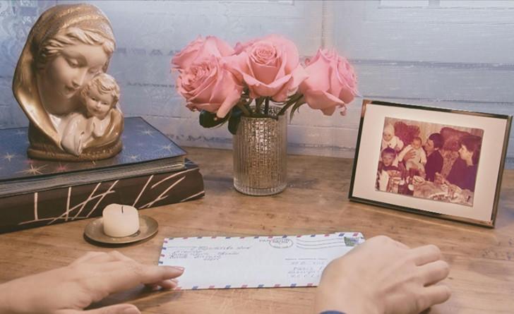 Sur une table, un courrier, des fleurs et une photo de famille