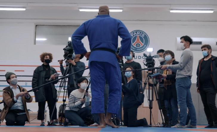 Teddy Riner, de dos, répondant à des journalistes