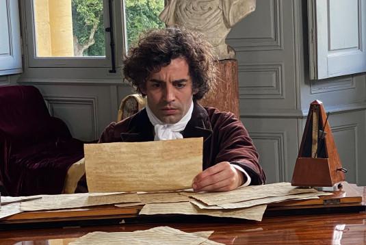 Photo d'un comédien interprétant Beethoven assis devant son piano