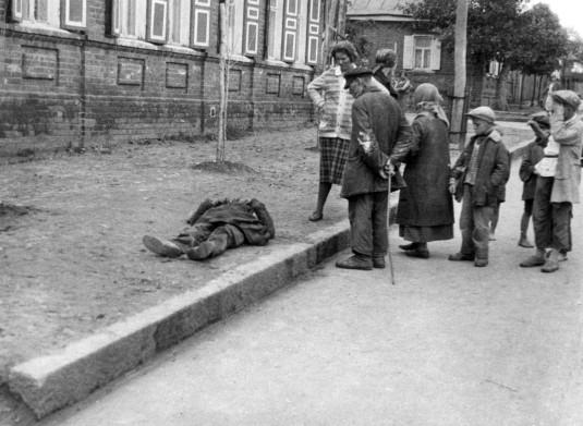 Kharkiv, Ukraine, 1933. Des passants regardent un homme mort de faim sur le trottoir. C'est une photo clandestine réalisée par Alexander Wienerberger