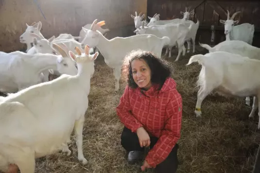Leïla pose au milieu de ses chèvres dans leur enclos